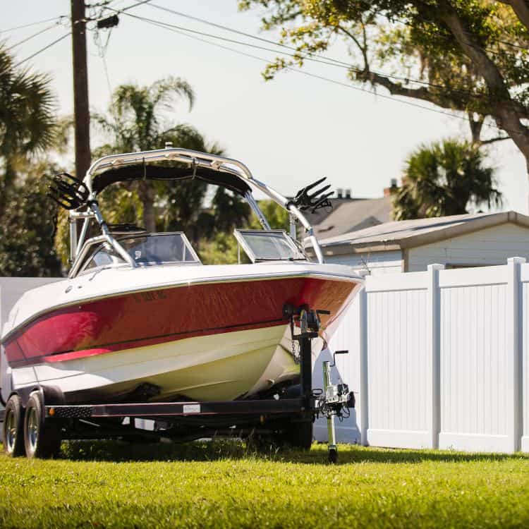 Boat in front of vinyl fence